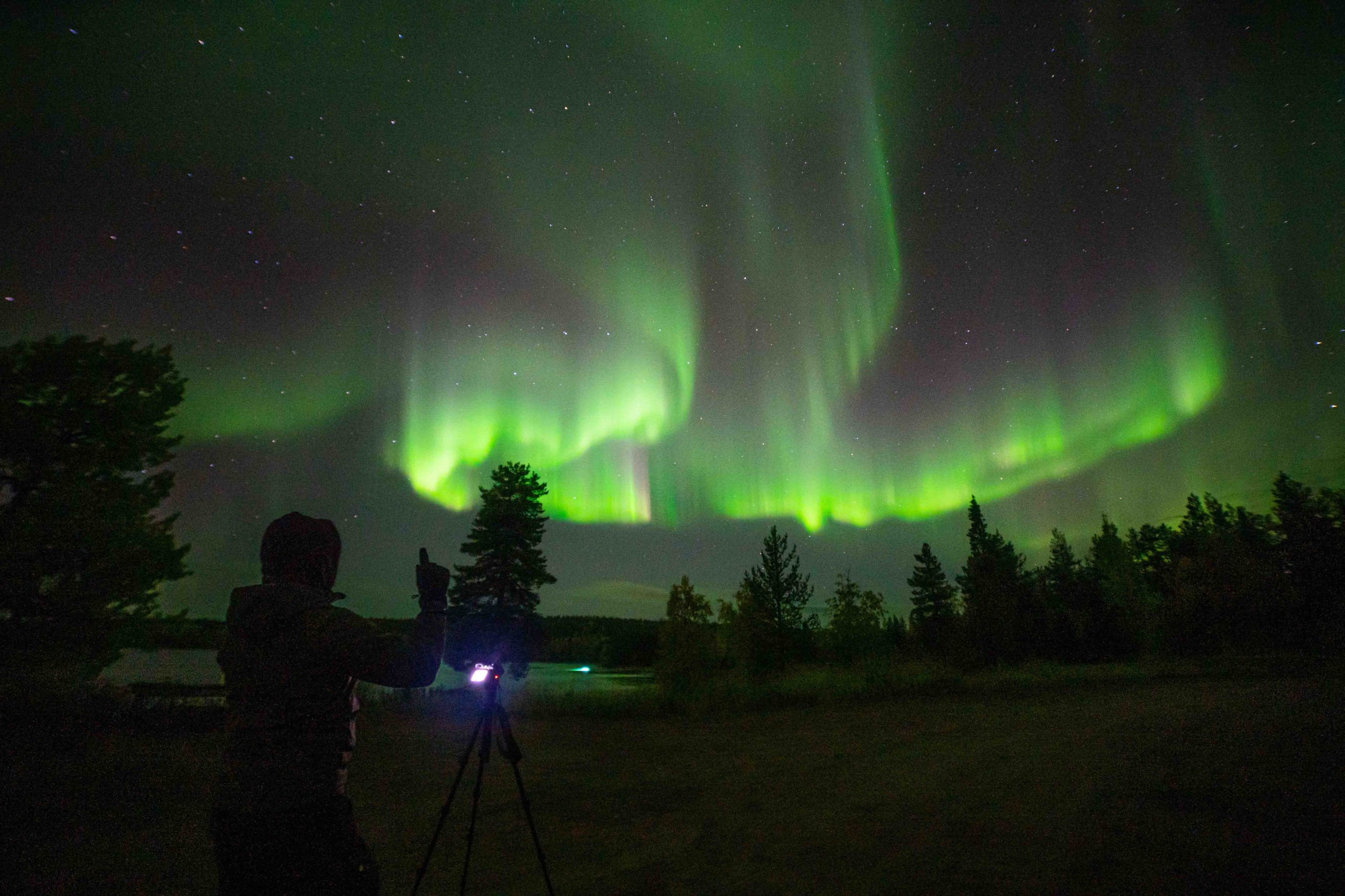 Photographer Long Exposure Northern Lights Storm By the Lake Autumn Lapland Rovaniemi