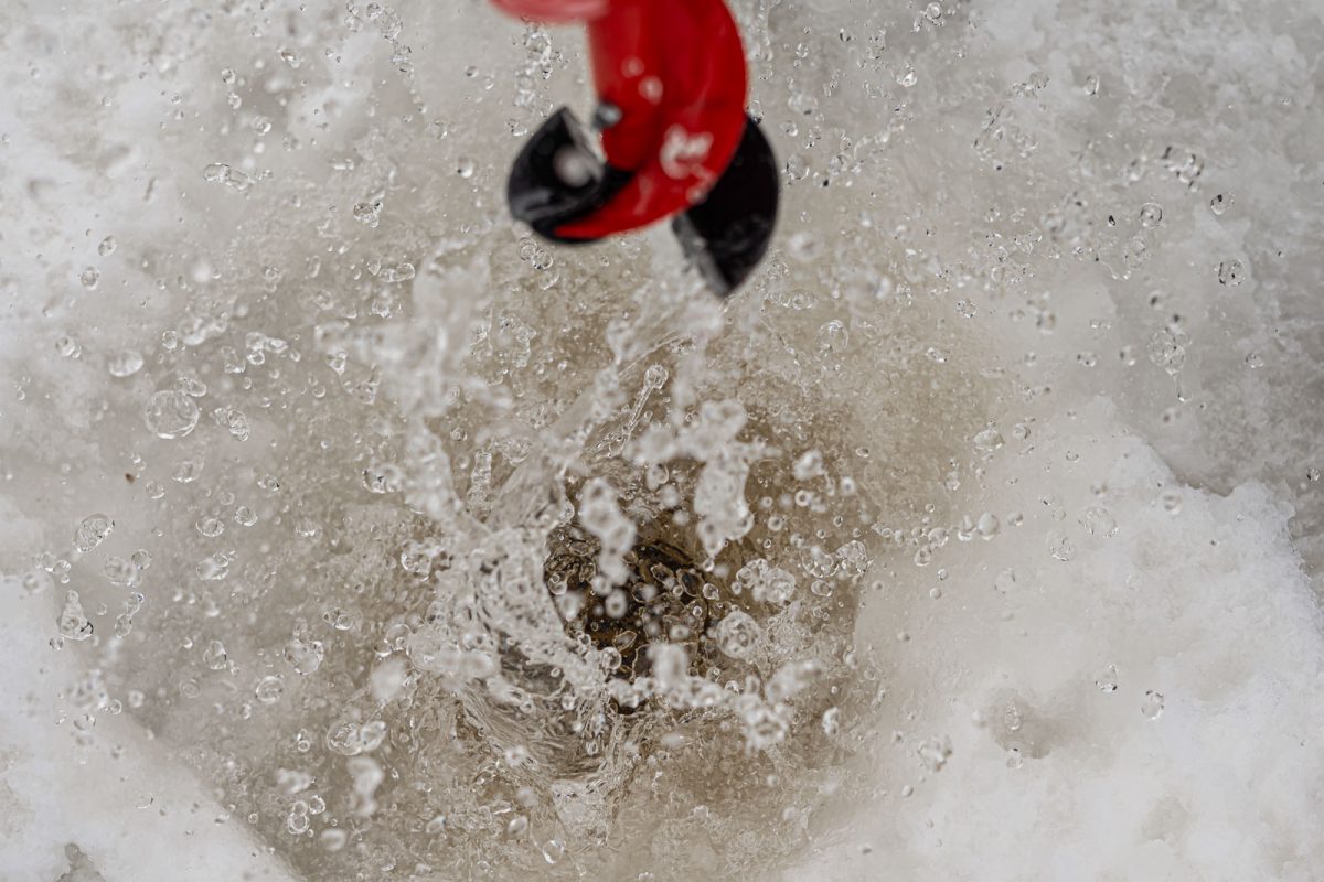 Using an auger to drill an ice-fishing hole