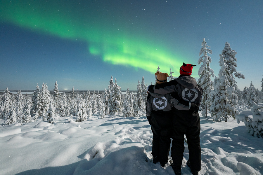 Couple standing beneath the Northern Lights