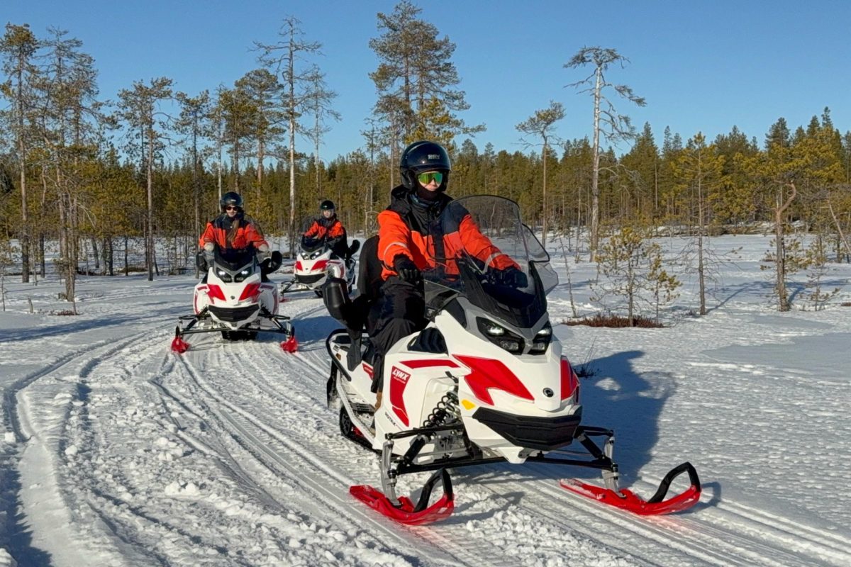 Electric snowmobile riders travelling to the reindeer enclosure