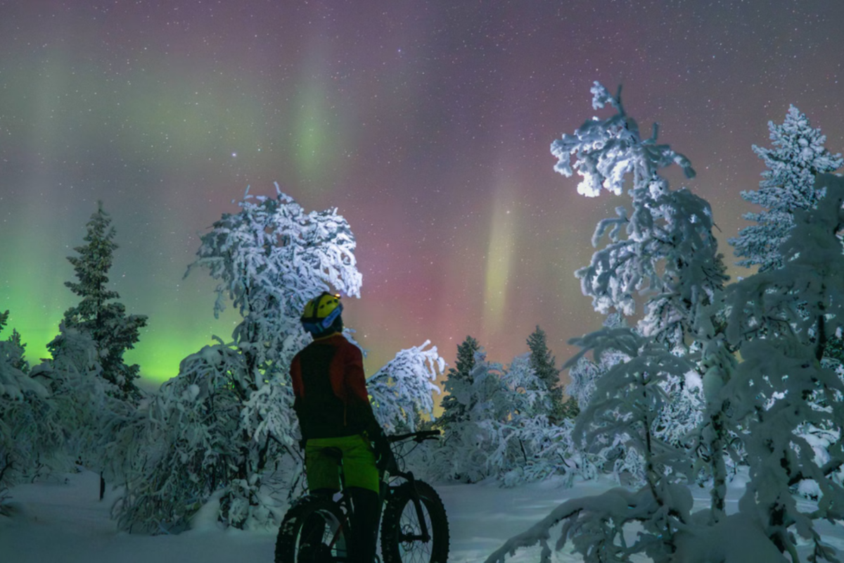 Aurora over a winter fatbike route in Pyhä-Luosto