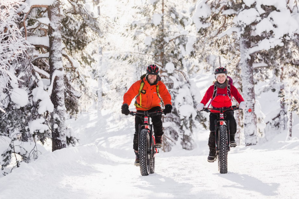 Electric fatbike rider on a snowy forest trail in Pyhä