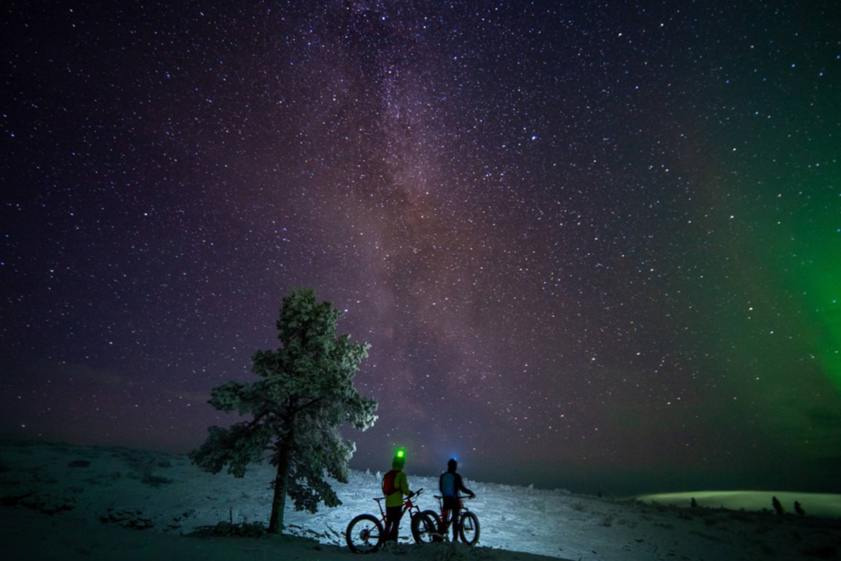 Electric fatbike beneath the Northern Lights near Pyhä