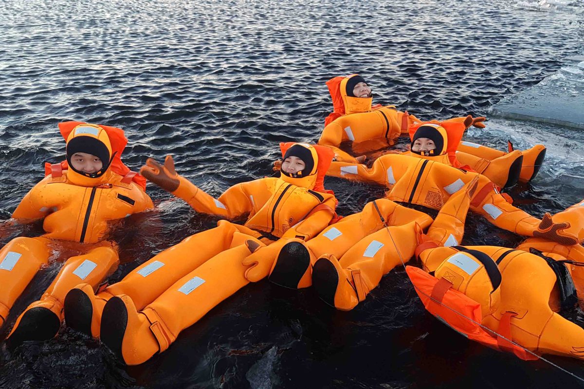 Passengers floating in survival suits in the frozen sea