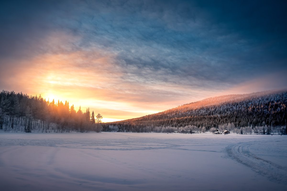 Frozen lake and forest at sunset near Levi