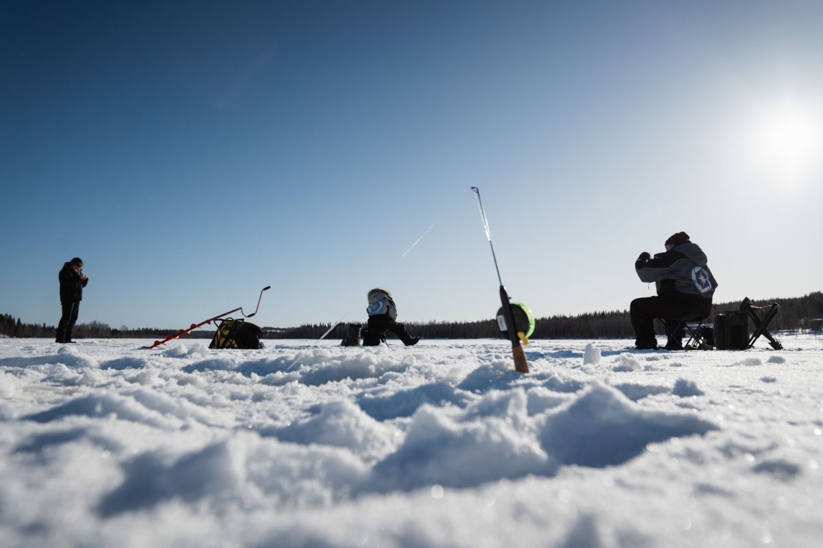 Ice-fishing equipment and an auger on a frozen lake in Lapland