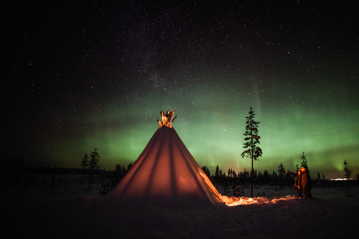 Couple by a campfire at a private Aurora location