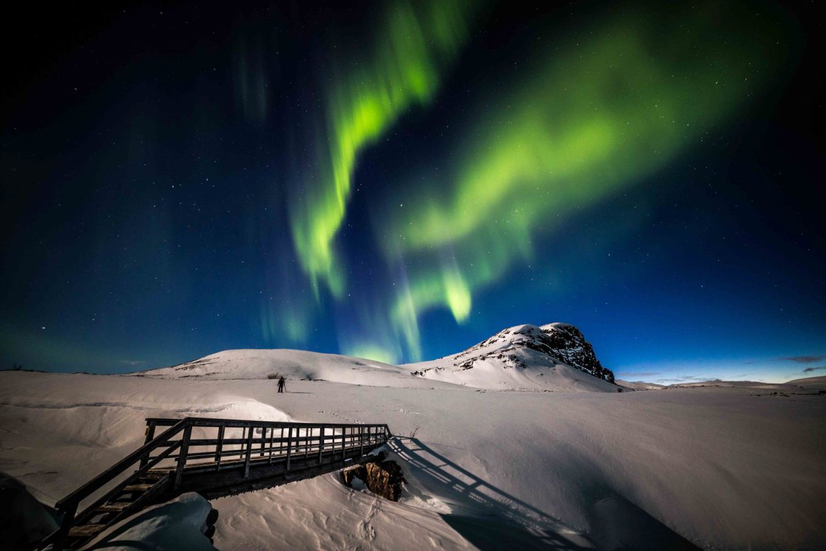 Photographer watching the Northern Lights over a fell