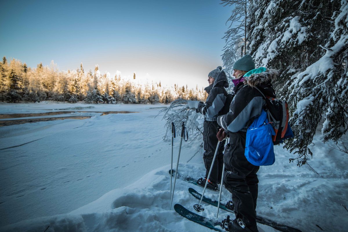Skiers beside a frozen river