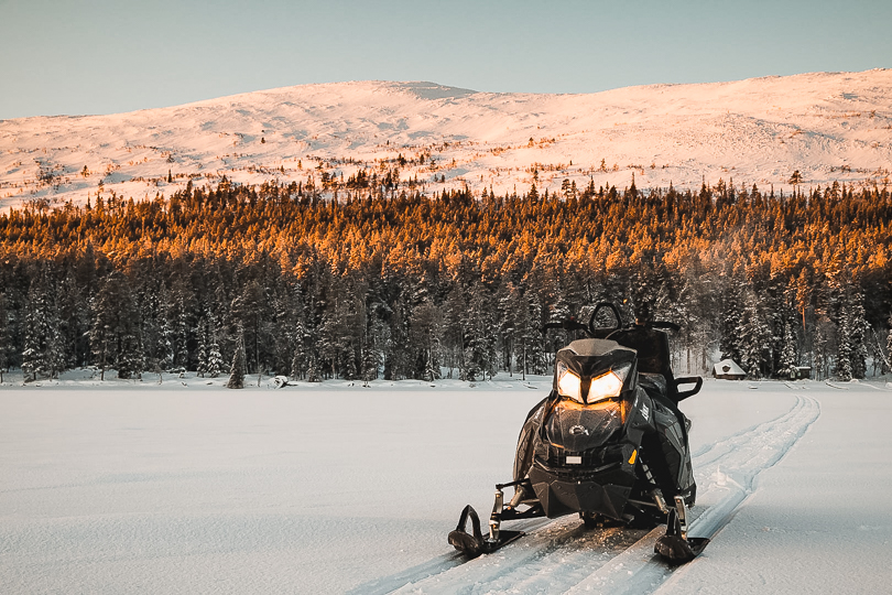 Snowmobile adventure in the forest and fell landscape near Levi
